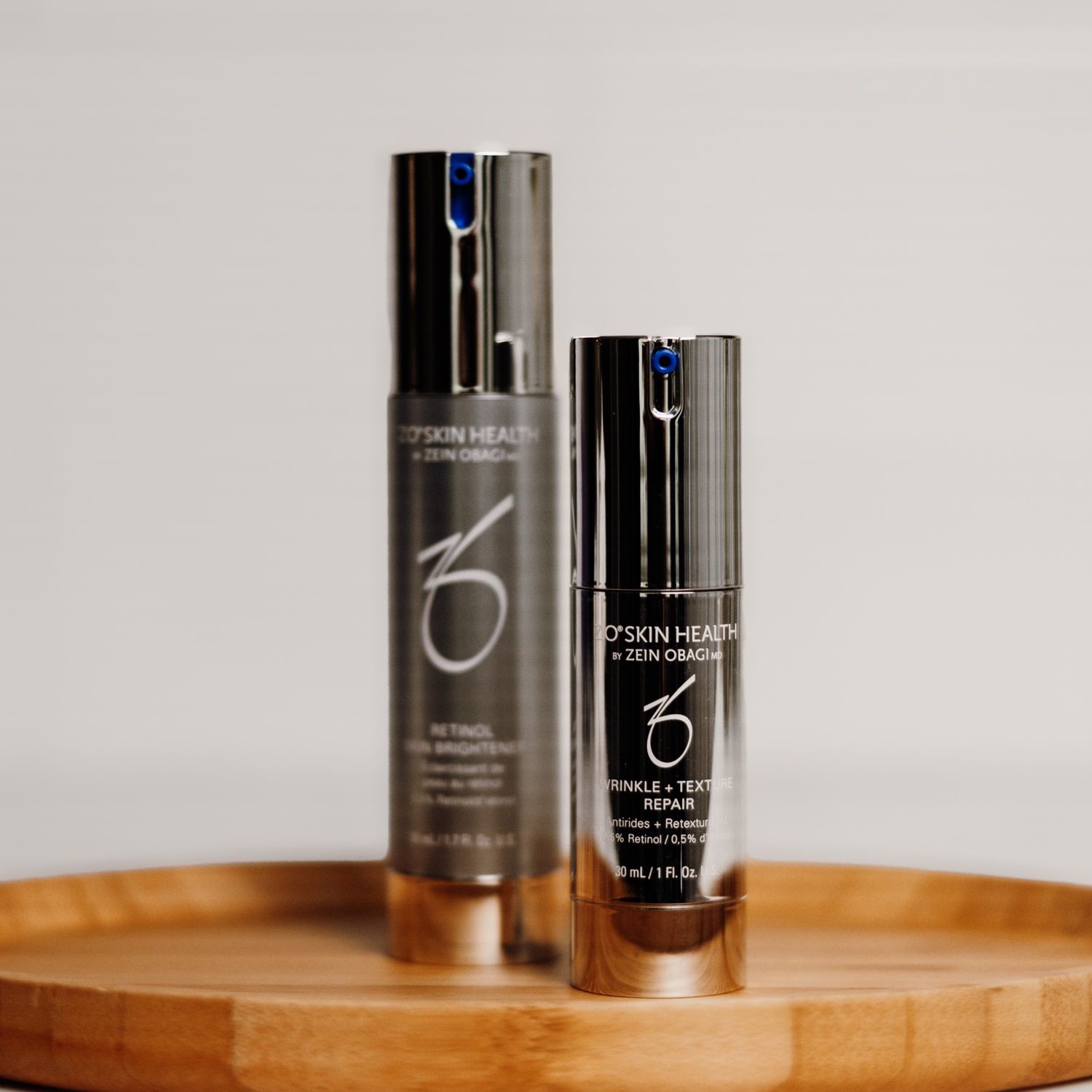 Two cosmetic bottles reflected in water.